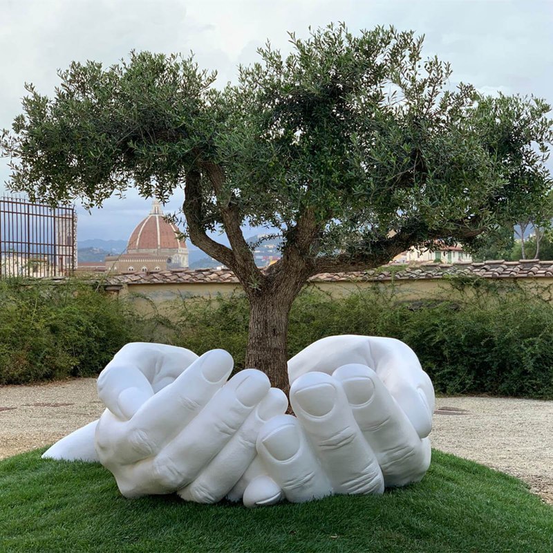 Giant hands holding an tree marble sculpture