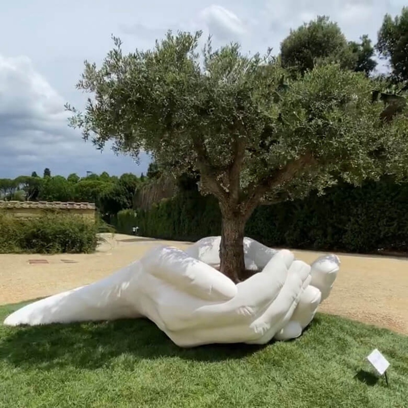 Giant hands holding an tree sculpture