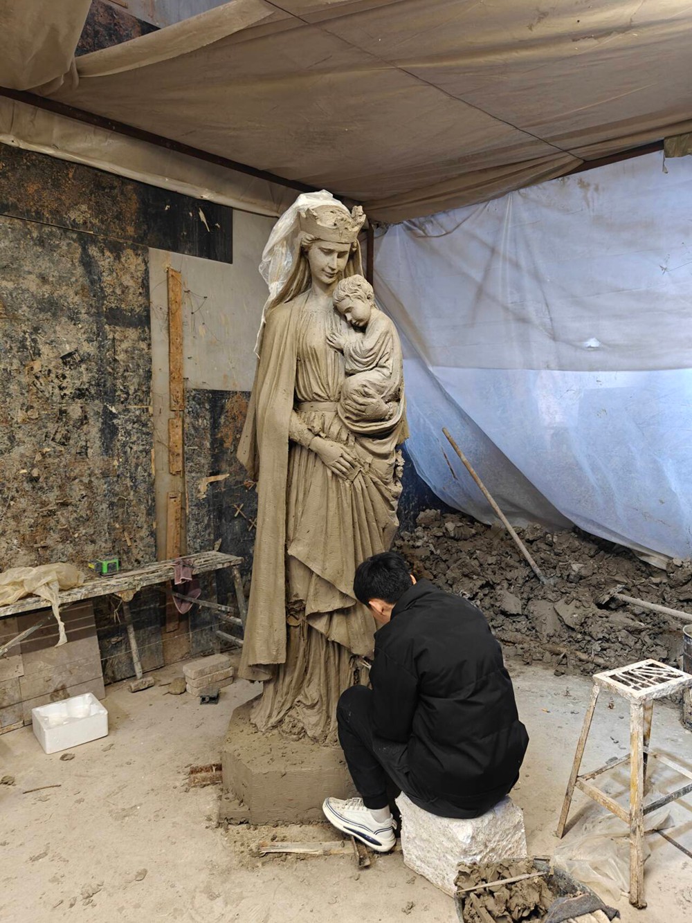 sculptor sculpting clay model of Virgin Mary and Child