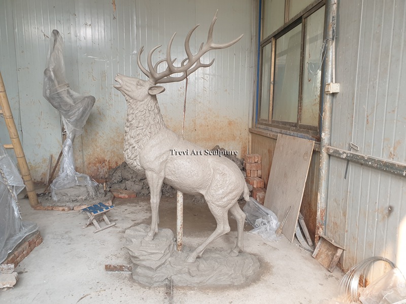 Full-size clay model of an elk posed on a rock