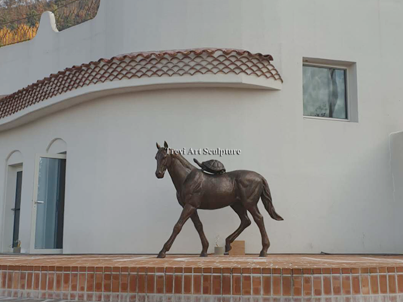 Custom bronze horse and turtle sculpture installed in front of a house