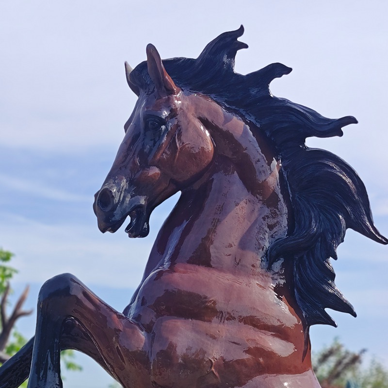 Glossy brown bronze rearing horse head outdoors