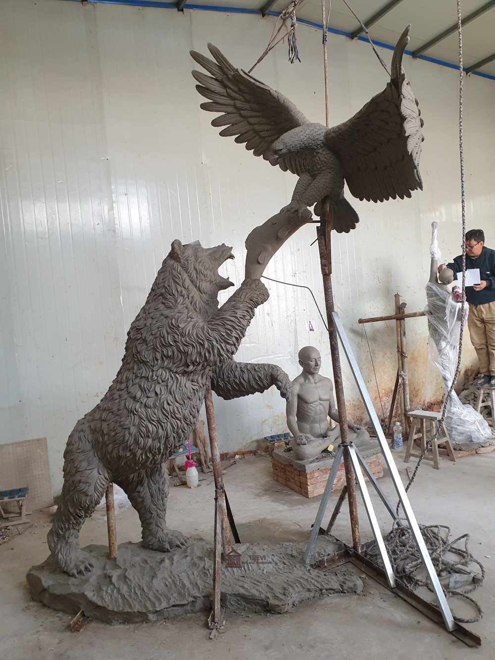 Clay model of a bear and eagle composition in a workshop