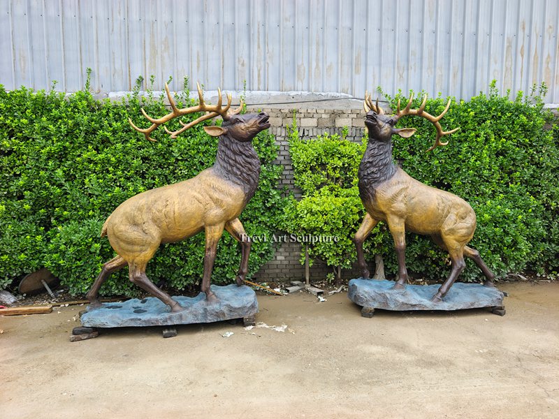 A pair of finished bugling bronze elk sculptures