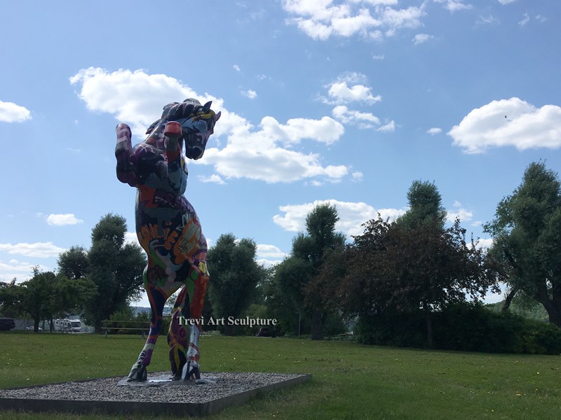 Colorfully painted rearing bronze horse sculpture in a customer setting
